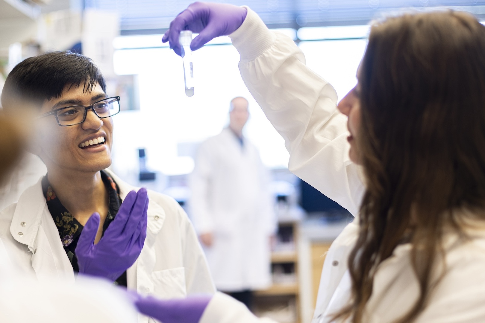 samir faruq in a lab with another student examining a test tube